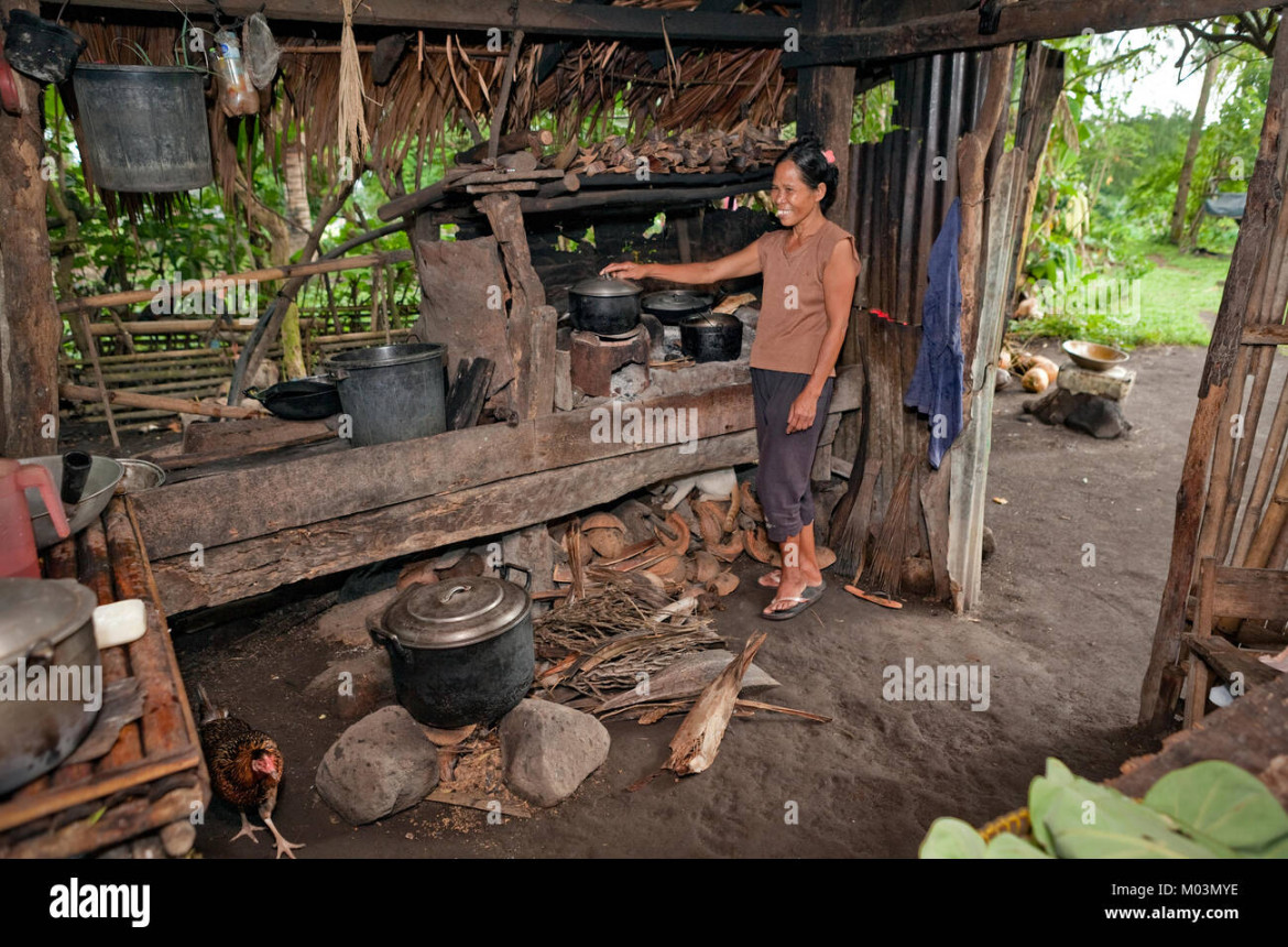 Ein Filipino Frau kocht eine Mahlzeit über offener Flamme in Ihrem