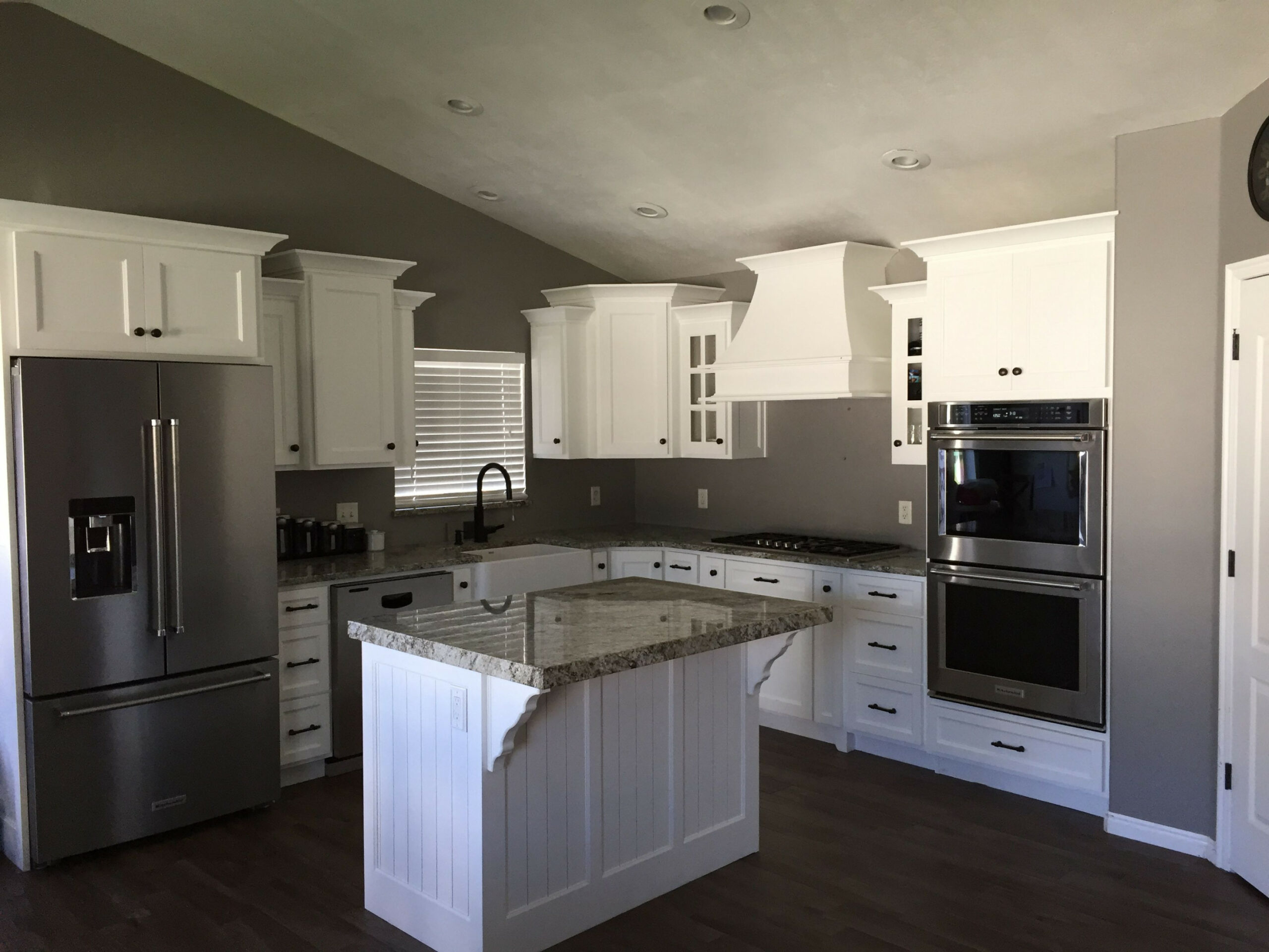 Grey walls with white kitchen cabinets and oil rubbed bronze