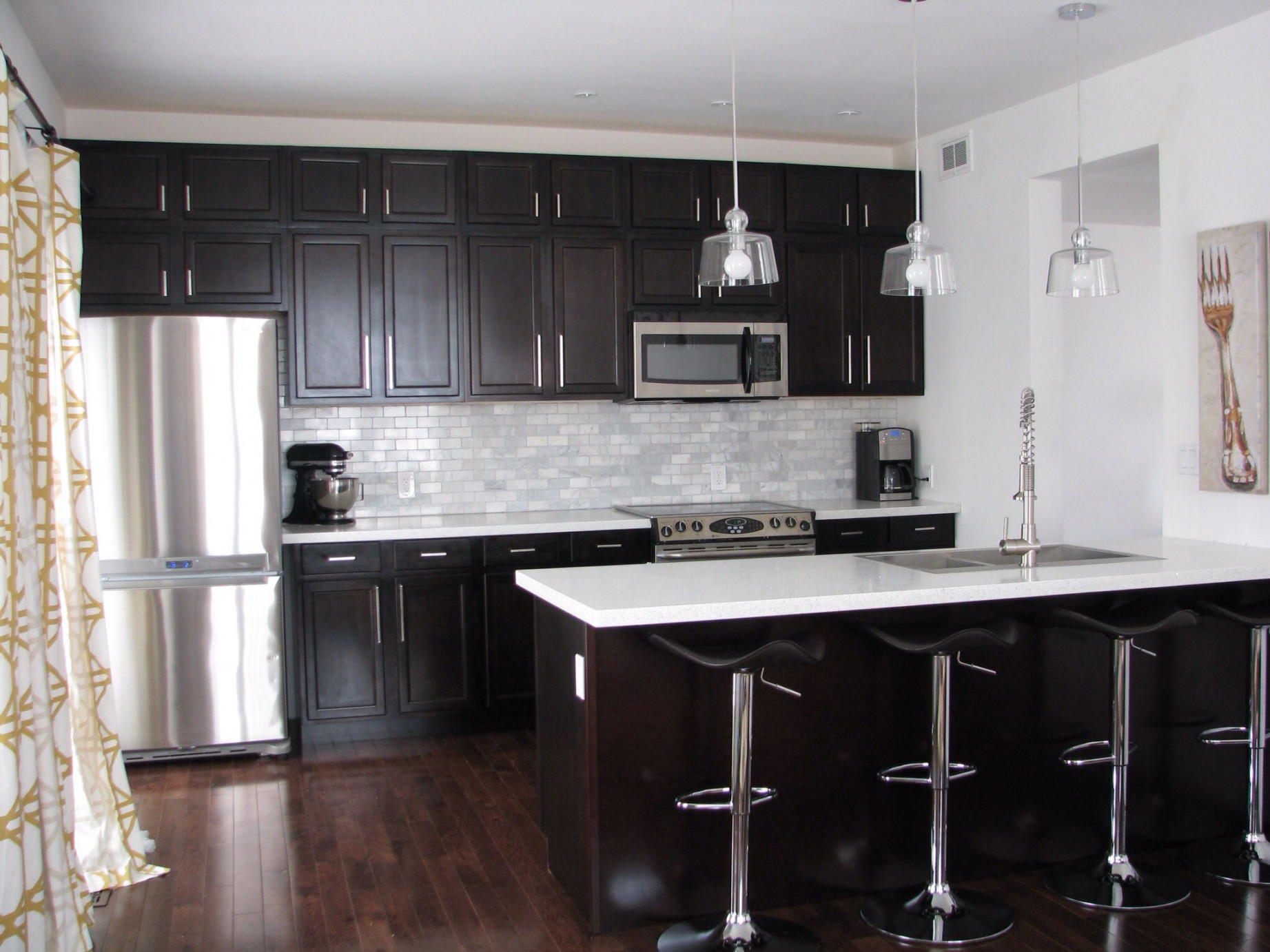 Kitchen with dark cabinets and white quartz counters  White