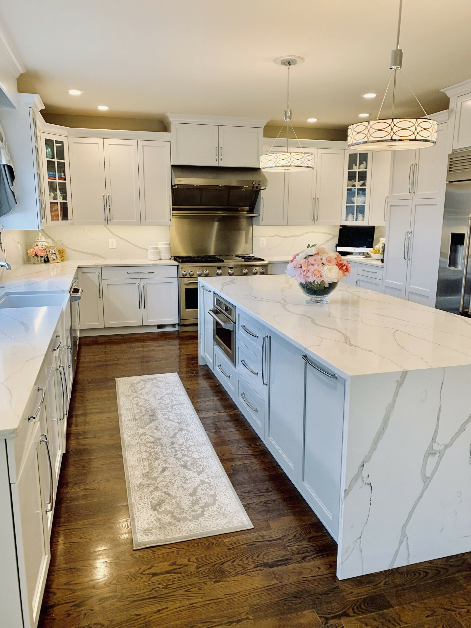 White kitchen done with quartz countertops, backsplash and