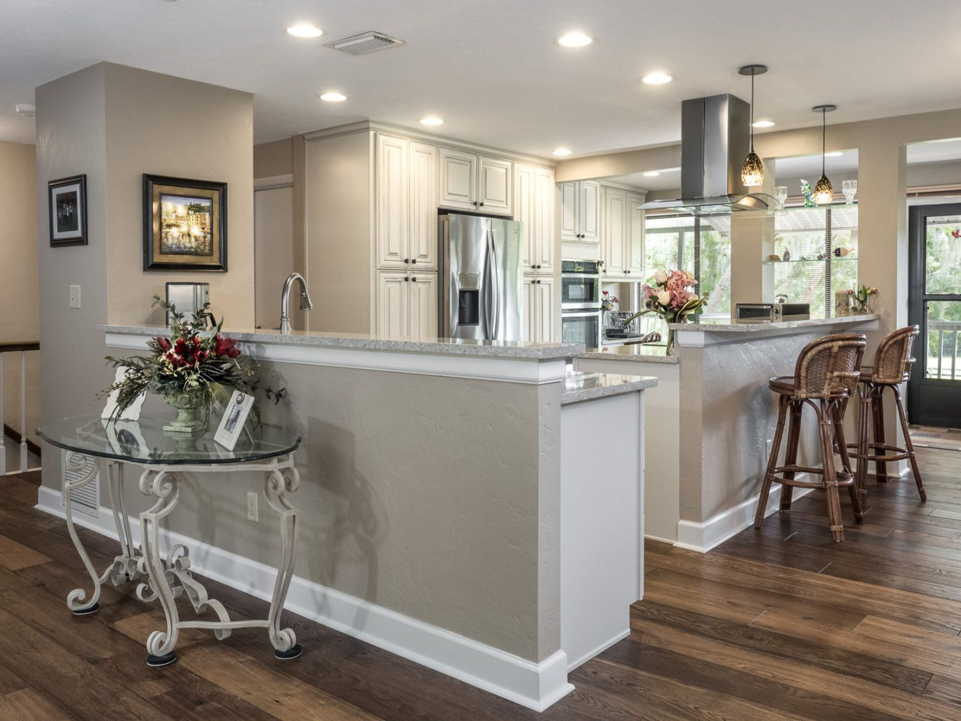 Open Kitchen in cream colored cabinets, wood floors, stainless