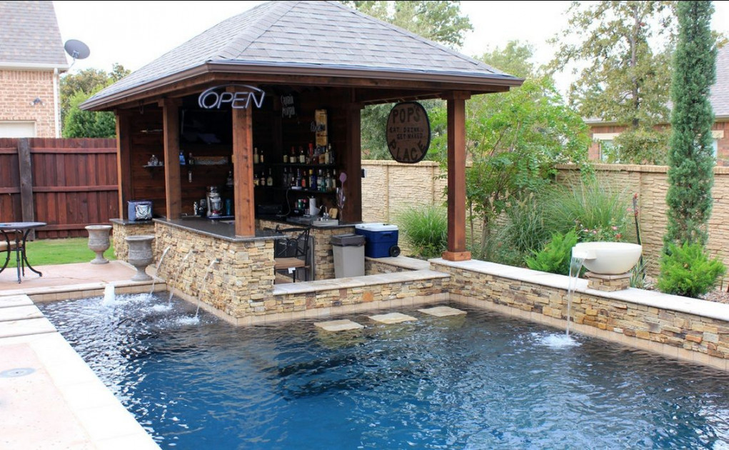 This custom swimming pool features a unique outdoor bar area with